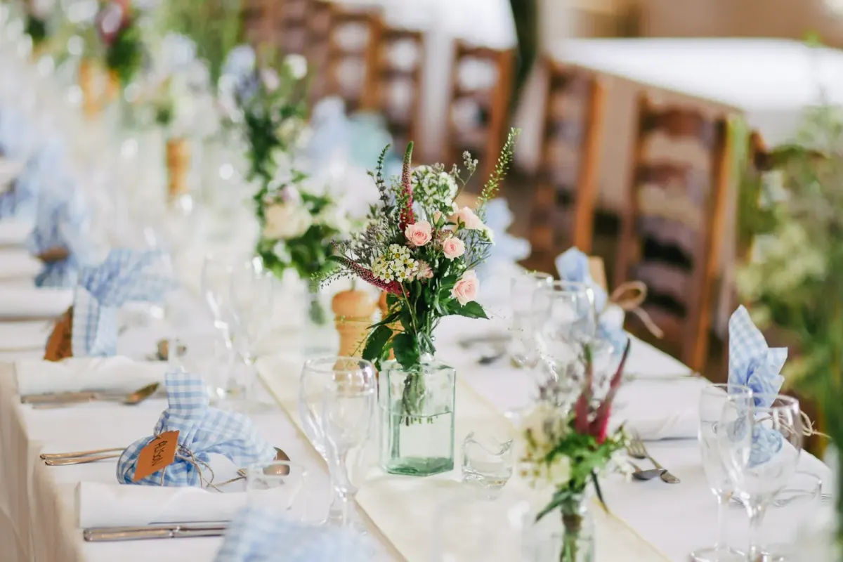 Open lawn ceremony setting with wooden chairs facing a simple floral arch.